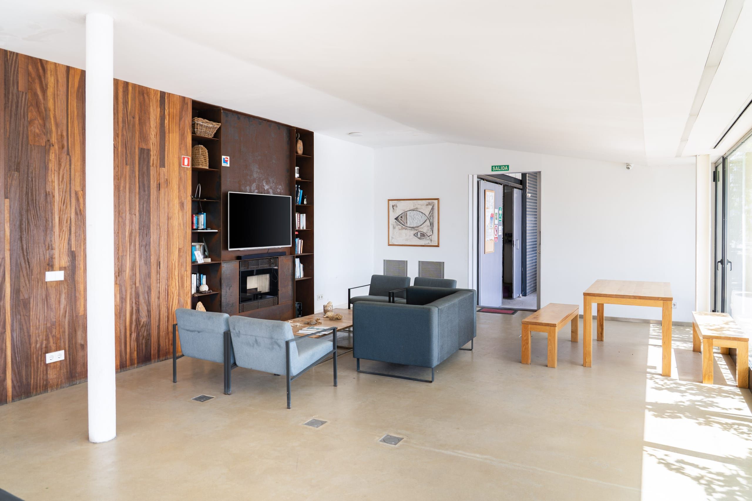 Crew Club seating area with a fireplace, sofas and wooden tables