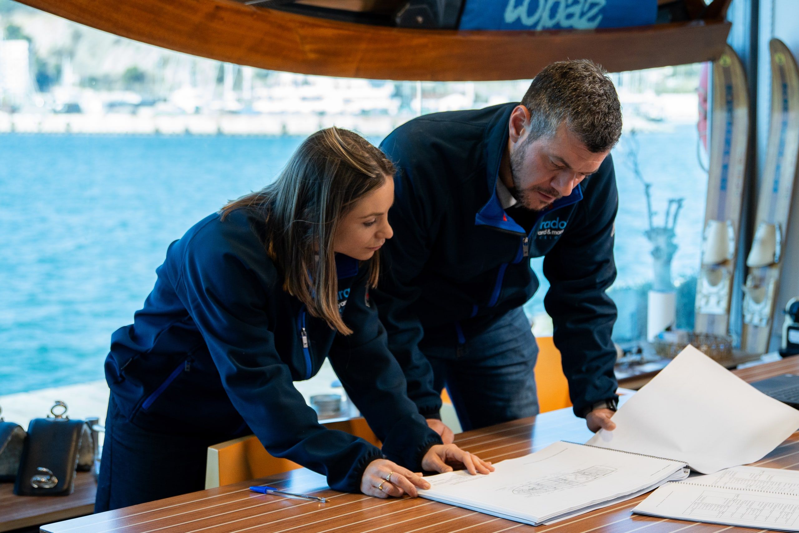 Dos miembros del equipo de Varador 2000 revisando los planos de un refit a bordo