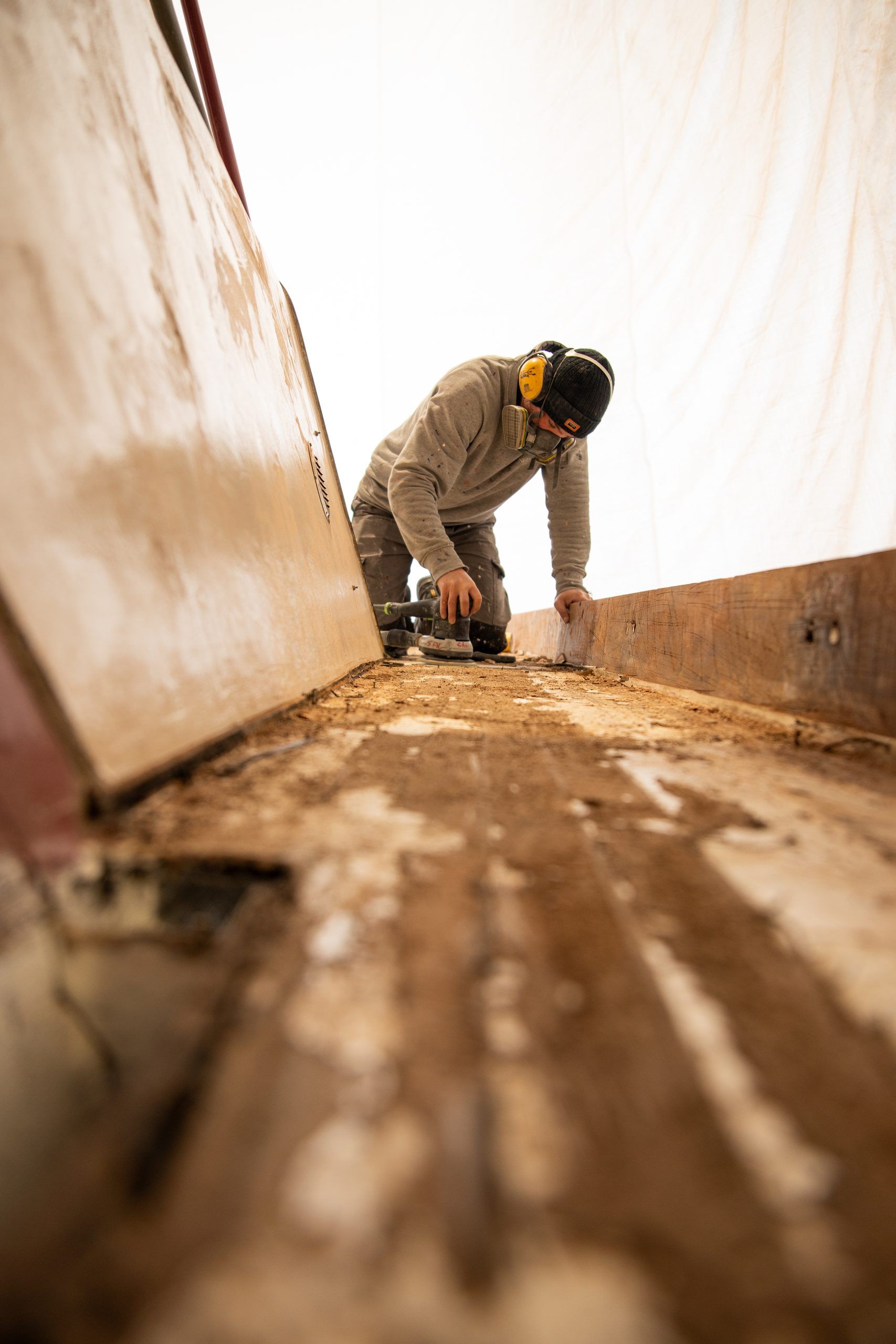 Carpenter sanding the inside of a vessel